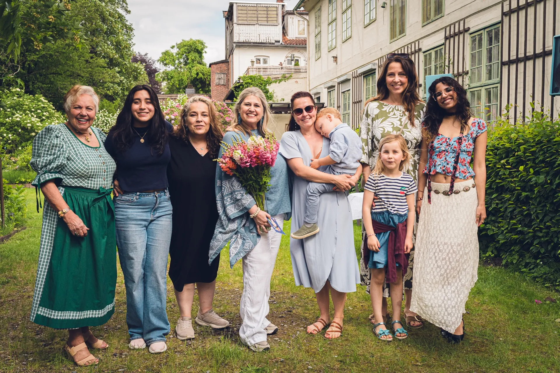 Eine Gruppe Frauen steht lachend mit Blumensträußen zusammen.