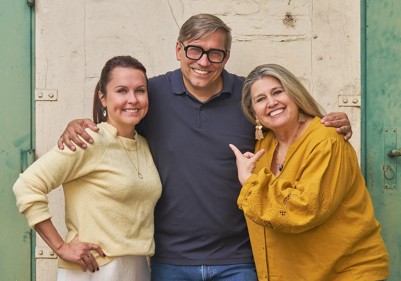 Sylvia Wagner, Roman Thomas und Zandra Gröschner Rico del Valle, der Vorstand von Denk.Mal, stehen vor einer alten Tür und lachen.